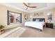 Comfortable primary bedroom with a ceiling fan, tray ceiling, and large windows at 9228 Sori Ln, Highlands Ranch, CO 80126