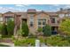Charming home exterior features a stone facade, arched window, private balconies and lovely landscaping at 9228 Sori Ln, Highlands Ranch, CO 80126