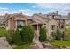 An exterior view of the home with stone and stucco facade and manicured lawn at 9228 Sori Ln, Highlands Ranch, CO 80126
