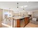 Kitchen island with stainless steel dishwasher, granite countertop and views of dining and living areas at 9228 Sori Ln, Highlands Ranch, CO 80126