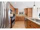 Beautiful kitchen with stainless steel appliances, granite counters, wood cabinets, and modern lighting at 9228 Sori Ln, Highlands Ranch, CO 80126