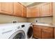 Functional laundry room featuring a modern washer and dryer, ample cabinetry, and a utility sink at 9228 Sori Ln, Highlands Ranch, CO 80126