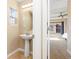 This powder room features a pedestal sink and leads to a bedroom bathed in natural light at 9228 Sori Ln, Highlands Ranch, CO 80126