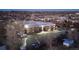 Aerial view of apartments with ample parking nestled among mature trees at dusk at 5995 W Hampden Ave # 3H, Denver, CO 80227