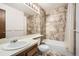 Bathroom with updated shower-tub combination with decorative tiled walls and neutral-toned vanity at 7790 W 87Th Dr # H, Arvada, CO 80005