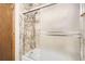 Updated bathroom with modern shower-tub combination featuring decorative tile walls and a glass sliding door at 7790 W 87Th Dr # H, Arvada, CO 80005