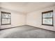 Bright bedroom with neutral carpet, fresh paint, and natural light from two large windows at 7790 W 87Th Dr # H, Arvada, CO 80005