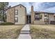 Exterior elevation featuring a stone facade, multiple units, and a well-manicured front yard at 7790 W 87Th Dr # H, Arvada, CO 80005