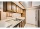Functional kitchen featuring wood cabinets, stainless steel sink, and ample counter space at 7790 W 87Th Dr # H, Arvada, CO 80005