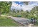 A scenic park view with benches surrounded by lush greenery and trees with a paved walking path under a cloudy sky at 7790 W 87Th Dr # H, Arvada, CO 80005