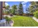 Backyard with large lawn and stone-lined planting beds surrounding a patio with outdoor seating at 16247 E Belleview Pl, Centennial, CO 80015