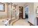 Luxurious bathroom featuring a tiled shower with glass surround and an archway leading to a walk-in closet at 16247 E Belleview Pl, Centennial, CO 80015