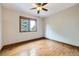 Bedroom featuring hardwood floors, neutral walls, and a window with blinds, providing ample natural light at 16247 E Belleview Pl, Centennial, CO 80015