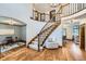 Stunning foyer with hardwood floors, curved staircase, and elegant lighting fixtures at 16247 E Belleview Pl, Centennial, CO 80015