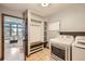 Charming mud room with built-in storage, coat hooks, and laundry appliances at 16247 E Belleview Pl, Centennial, CO 80015