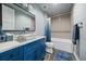 Bathroom featuring bold blue cabinets, tiled floors, large mirrors, and new fixtures at 2741 Morning Run Ct, Franktown, CO 80116
