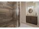 Modern bathroom with tiled walls, a glass shower, a wooden vanity, and new fixtures at 2741 Morning Run Ct, Franktown, CO 80116