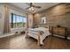 Cozy bedroom with a wood-paneled accent wall, rustic furniture, and a large window with natural light at 2741 Morning Run Ct, Franktown, CO 80116