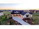 Stunning two-story home boasts a concrete driveway and beautiful landscaping against a serene sunset backdrop at 2741 Morning Run Ct, Franktown, CO 80116