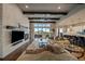 Open-concept living room with stone fireplace, wooden beams, and a seamless flow to outdoor space at 2741 Morning Run Ct, Franktown, CO 80116