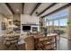 Bright living room with fireplace, wooden beams, and large windows showcasing outdoor views at 2741 Morning Run Ct, Franktown, CO 80116