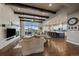 Bright, open living room connected to kitchen; features wood floors, beams, and fireplace at 2741 Morning Run Ct, Franktown, CO 80116