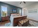 Comfortable main bedroom featuring an accent wall, wood floors, and a decorative bench in front of the bed at 2741 Morning Run Ct, Franktown, CO 80116