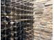 Close up of wine bottles stored in wooden racks with a stone wall in the background for a rustic feel at 2741 Morning Run Ct, Franktown, CO 80116