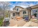 Exterior view of home with wood deck featuring a hot tub and grill at 9361 Crestmore Way, Littleton, CO 80126