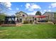 Expansive backyard featuring a gazebo-covered deck, comfortable seating area with a large umbrella, and lush green grass at 9361 Crestmore Way, Littleton, CO 80126
