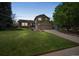 Charming two-story home featuring a lush green lawn, mature trees and an attached two-car garage at 9361 Crestmore Way, Littleton, CO 80126