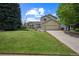 Charming two-story home featuring a lush green lawn, mature trees and an attached two-car garage at 9361 Crestmore Way, Littleton, CO 80126