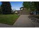 Charming two-story home featuring a lush green lawn, mature trees and an attached two-car garage at 9361 Crestmore Way, Littleton, CO 80126