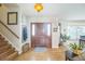 Inviting foyer with hardwood floors, stylish light fixture, and staircase with wooden banister at 9361 Crestmore Way, Littleton, CO 80126
