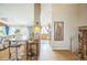 Open-concept living room into kitchen with hardwood floors and stylish bar stool seating at 9361 Crestmore Way, Littleton, CO 80126