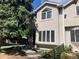 Charming two-story townhome featuring stucco exterior, large windows, and mature landscaping in a desirable neighborhood at 490 Jackson St, Denver, CO 80206
