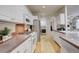 Well-lit kitchen with white cabinetry, stainless steel appliances, and views through to the laundry area at 490 Jackson St, Denver, CO 80206