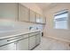 Bright laundry room with light gray cabinets and vinyl flooring at 7071 Greenwater Cir, Castle Rock, CO 80108