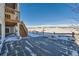 Concrete patio with stairs leading to a deck and snowy views at 7071 Greenwater Cir, Castle Rock, CO 80108