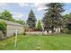 View of the spacious backyard featuring a lawn and a detached garage at 1551 S University Blvd, Denver, CO 80210