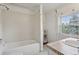 Functional bathroom featuring white tile in the shower/tub with natural light at 1551 S University Blvd, Denver, CO 80210