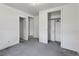 Comfortable bedroom with soft grey carpets, neutral walls, and multiple closets for storage at 1551 S University Blvd, Denver, CO 80210