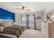 Cozy bedroom with blue accent wall, decorative curtains, and dresser at 643 S Norfolk Way, Aurora, CO 80017