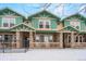 Townhome exterior with stone accents and painted siding, with covered porch and railing, and wintery front lawn at 643 S Norfolk Way, Aurora, CO 80017