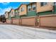 Row of garages for townhomes with neutral paint, creating a clean and uniform exterior, and snow on the ground at 643 S Norfolk Way, Aurora, CO 80017