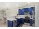 Charming kitchen with blue cabinets, stainless steel appliances, and a view into the dining area at 643 S Norfolk Way, Aurora, CO 80017