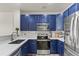 Modern kitchen featuring stylish blue cabinets, stainless steel appliances, and ample counter space at 643 S Norfolk Way, Aurora, CO 80017