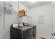 Bright laundry room featuring front load washer and dryer and shelving above for convenient storage solutions at 643 S Norfolk Way, Aurora, CO 80017