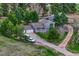 Charming home with two-car garage, covered porch, and long driveway surrounded by lush greenery and mature trees at 36700 Mossberg Ct, Elizabeth, CO 80107