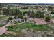 An aerial view of the property featuring the house, barn, and riding arena, surrounded by trees at 36700 Mossberg Ct, Elizabeth, CO 80107